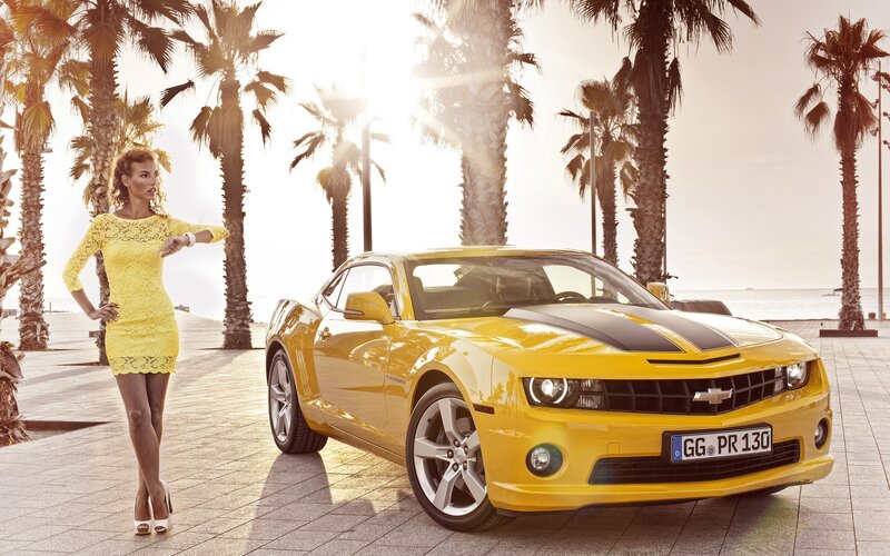 Woman with yellow car at beach
