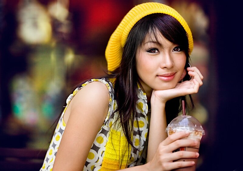 Woman with yellow hat holding drink