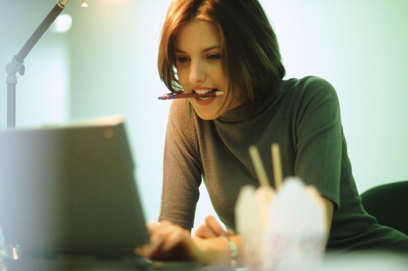 woman working at laptop with pen