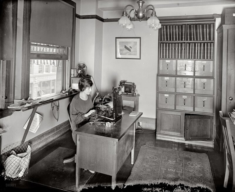 Woman working at typewriter in office