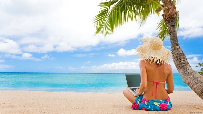 Woman working on laptop at beach