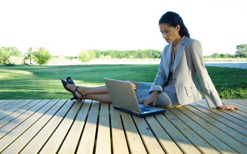 Woman working on laptop outdoors