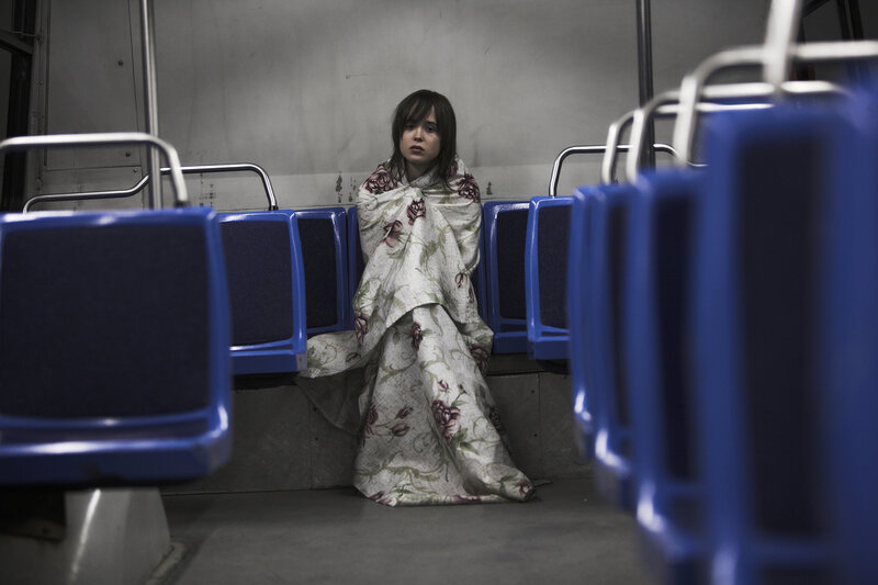 woman wrapped in blanket on bus