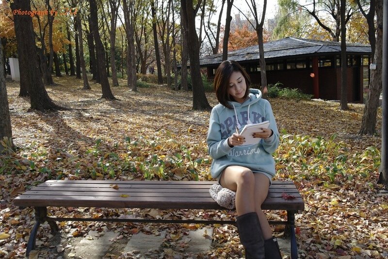 Woman writing in autumn park