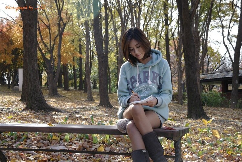 Woman writing in autumn park