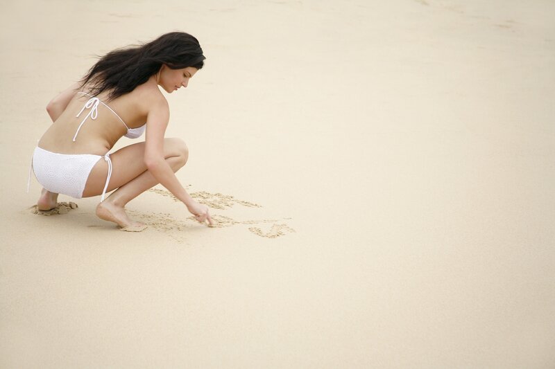 woman writing in the sand