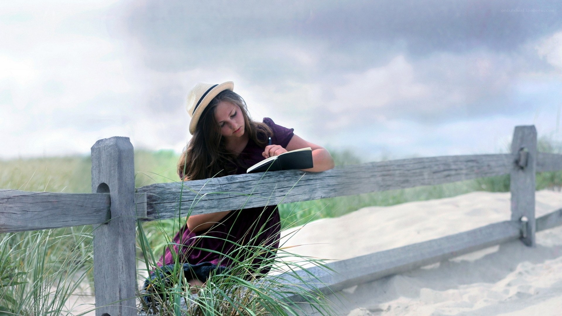 woman writing on beach