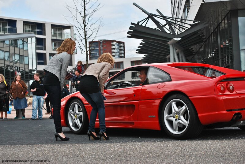 Women admiring red Ferrari