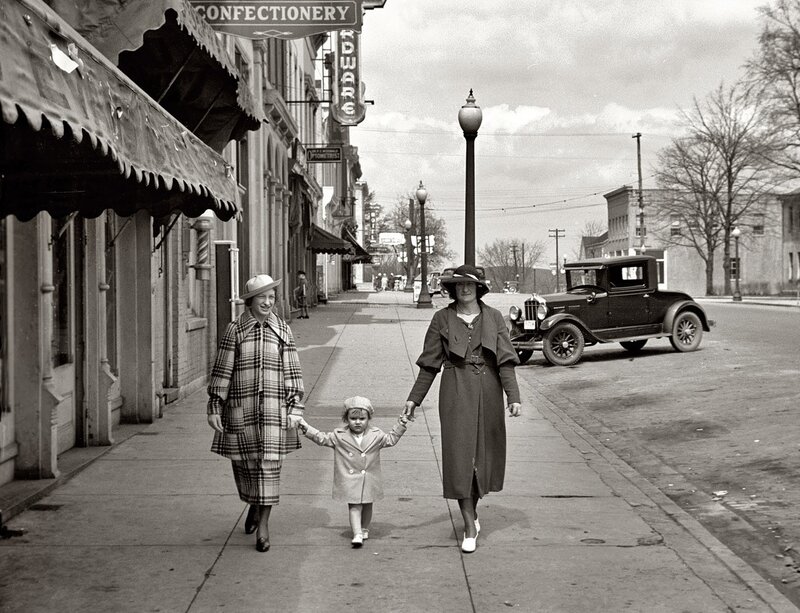Women and child walking on sidewalk