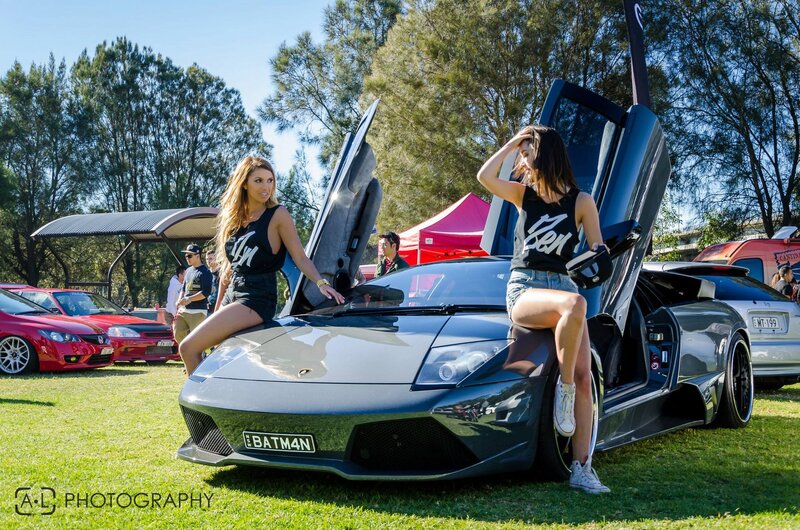 Women at a car show with Lamborghini