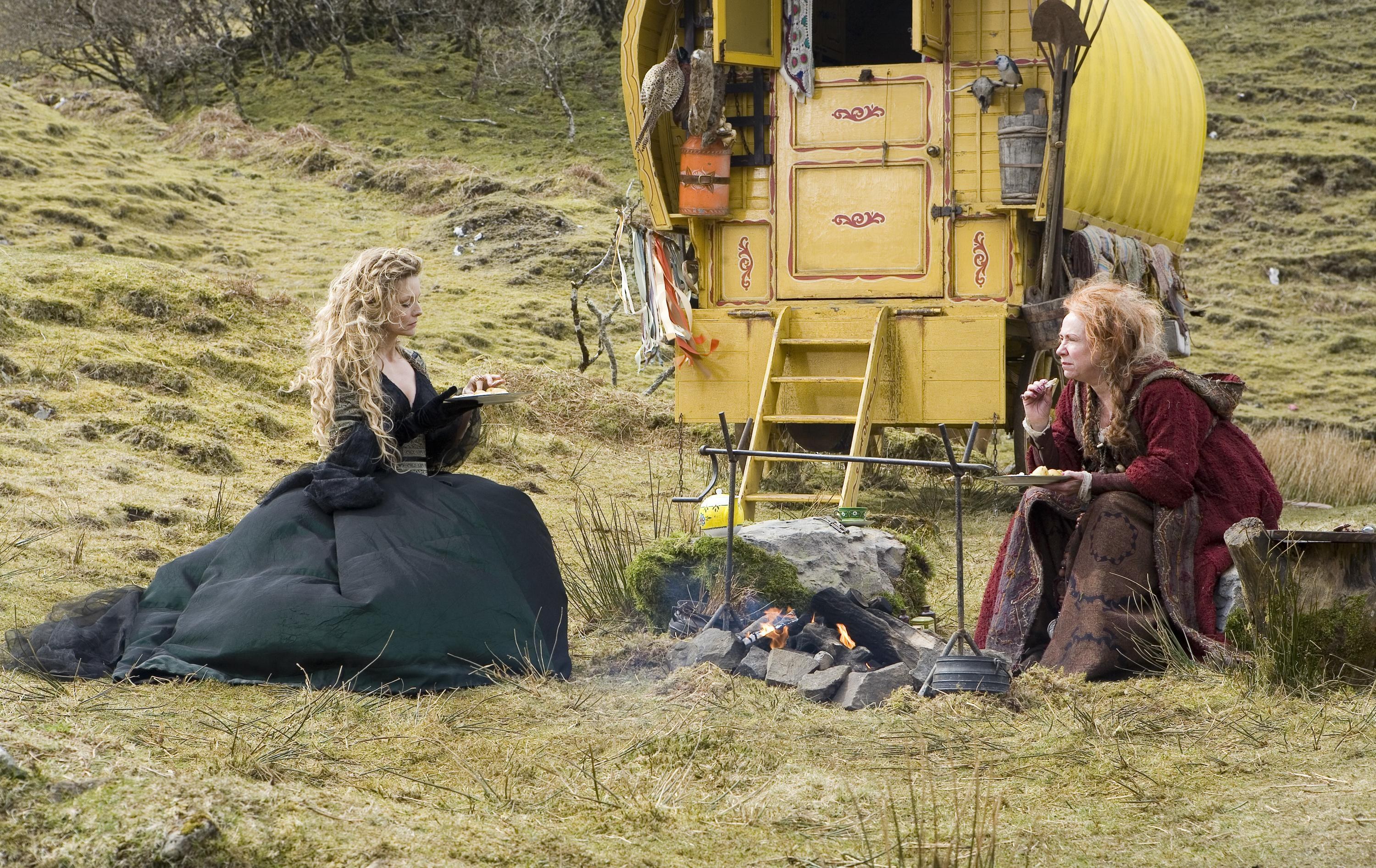 Women by a campfire with caravan