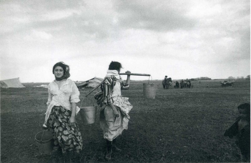 Women carrying buckets in a field