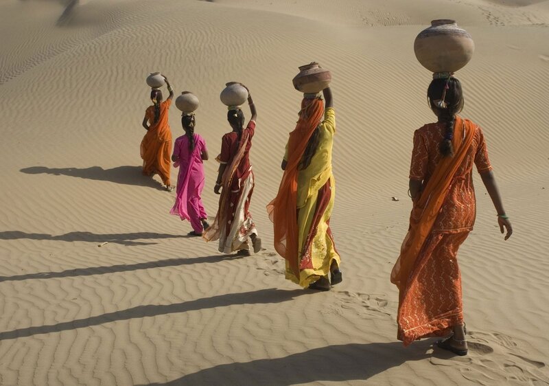 Women carrying water in desert