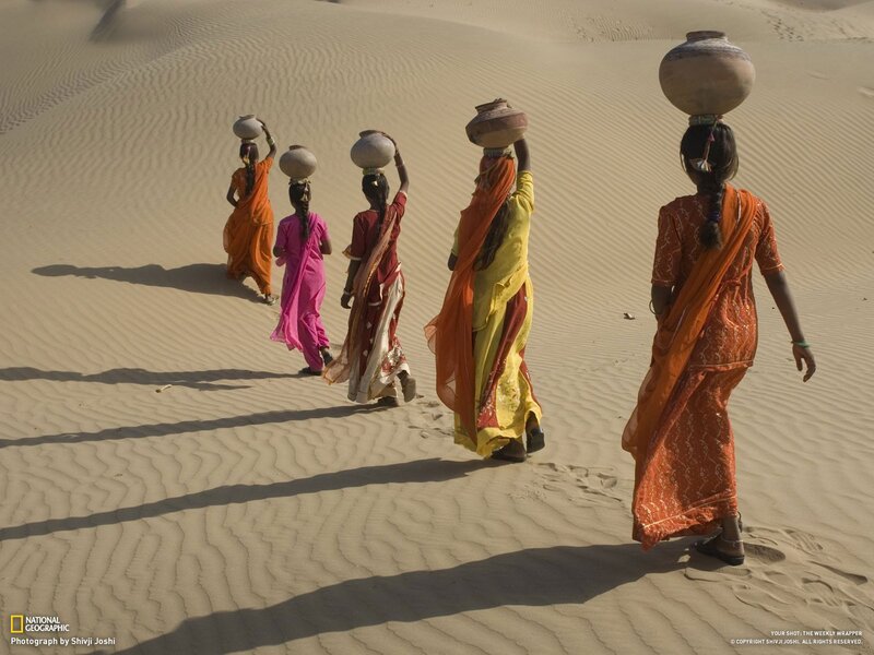 Women carrying water in desert