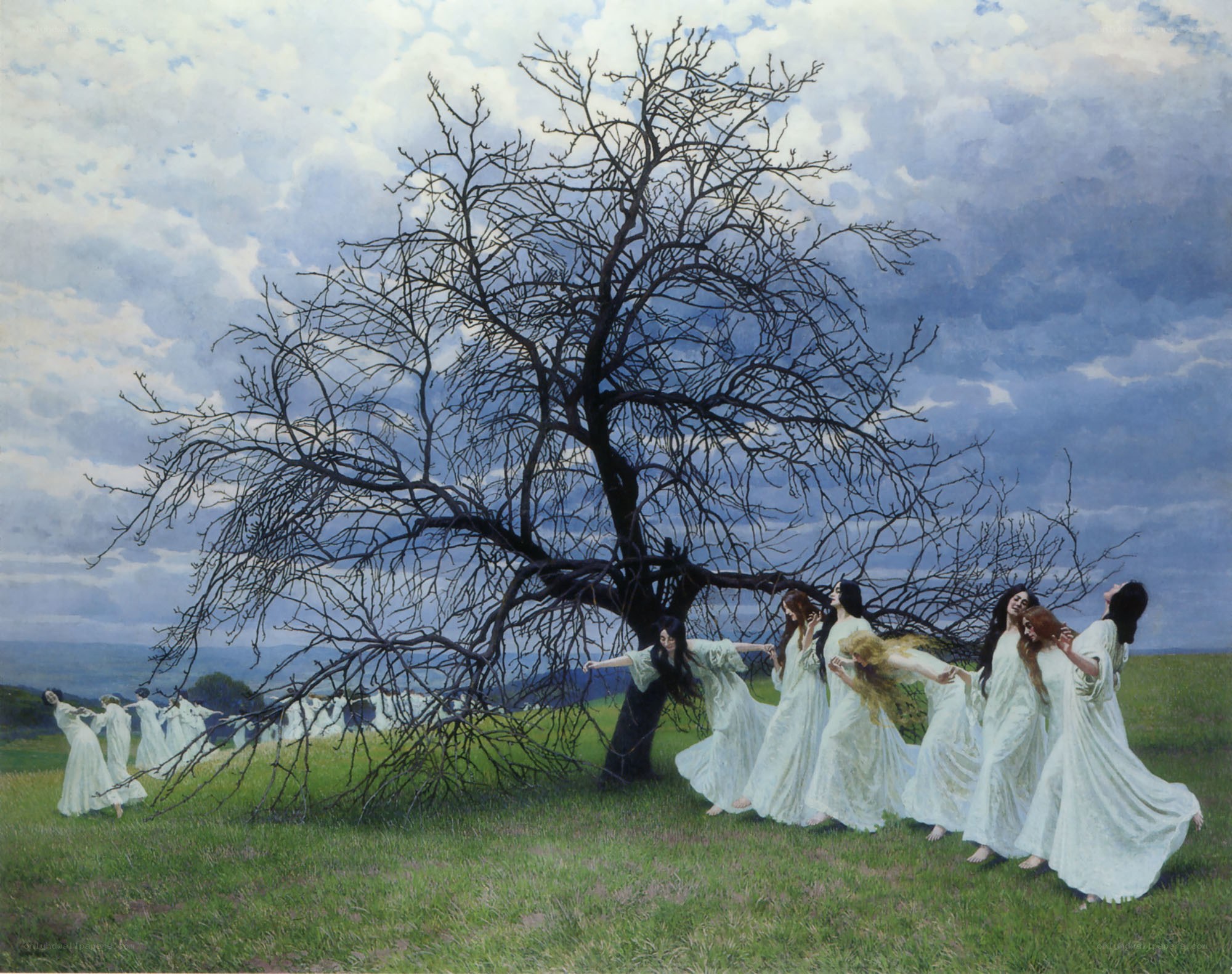 Women dancing around a bare tree