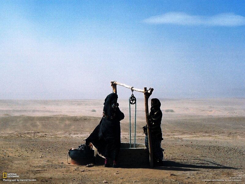 Women drawing water in desert