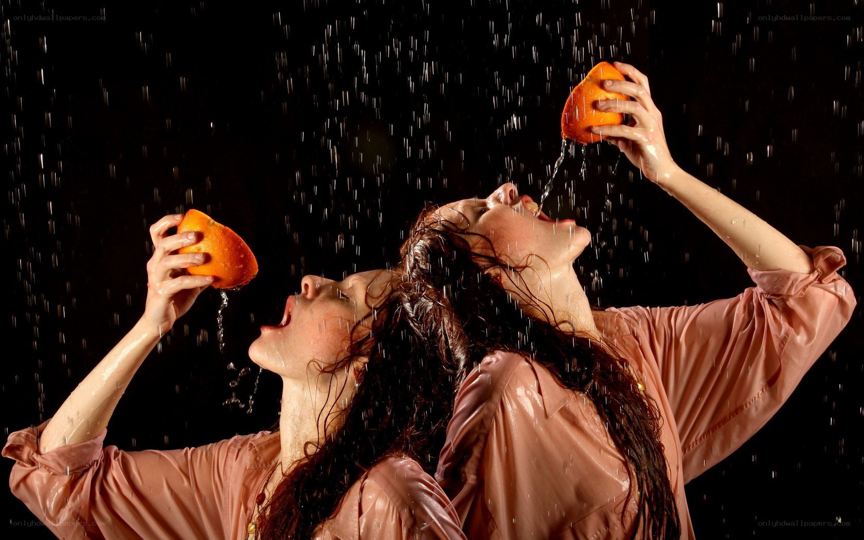 Women drinking water from oranges