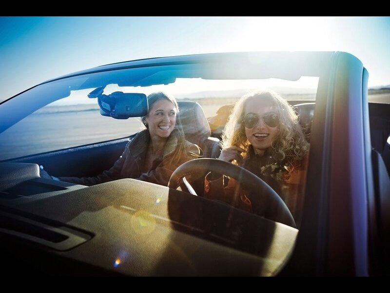 Women driving convertible car