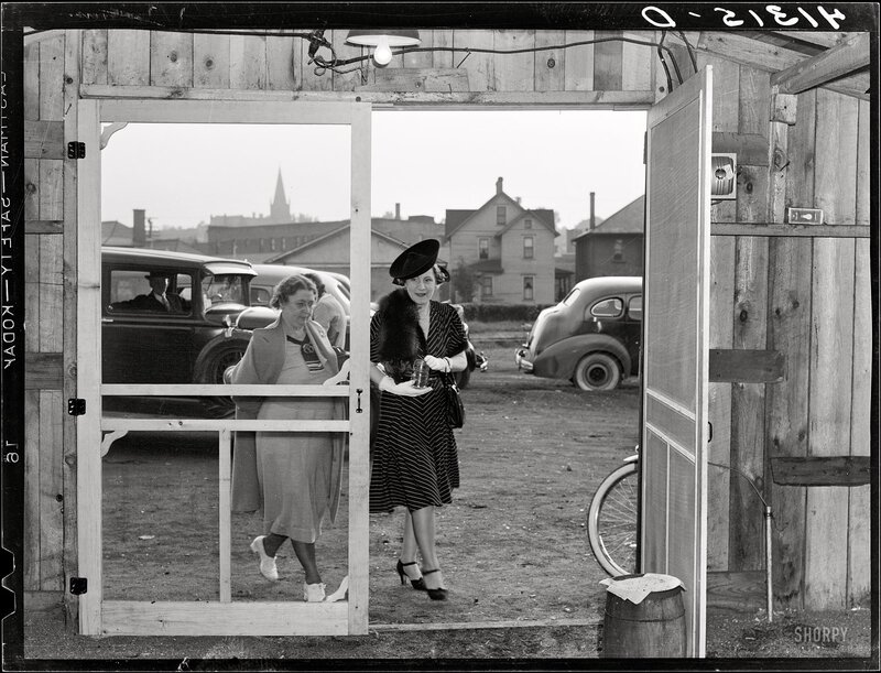 Women exiting a wooden shed