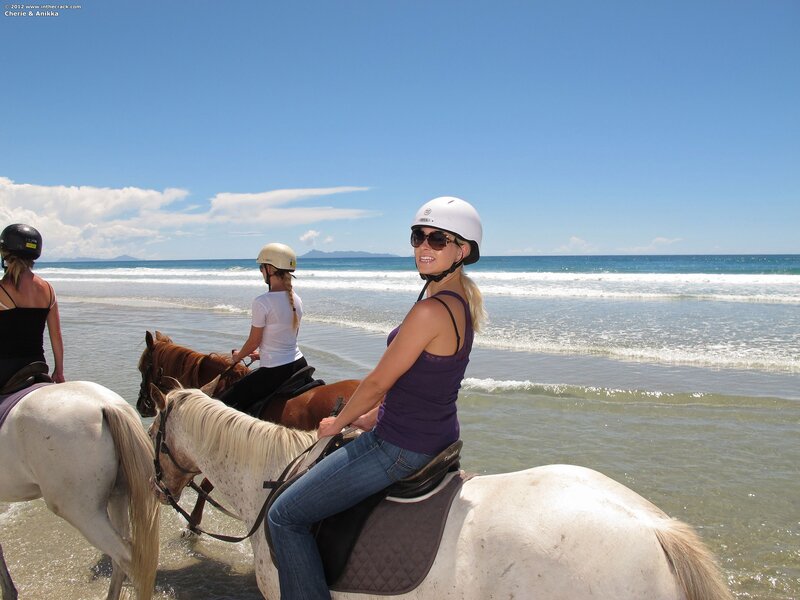 Women horseback riding on beach