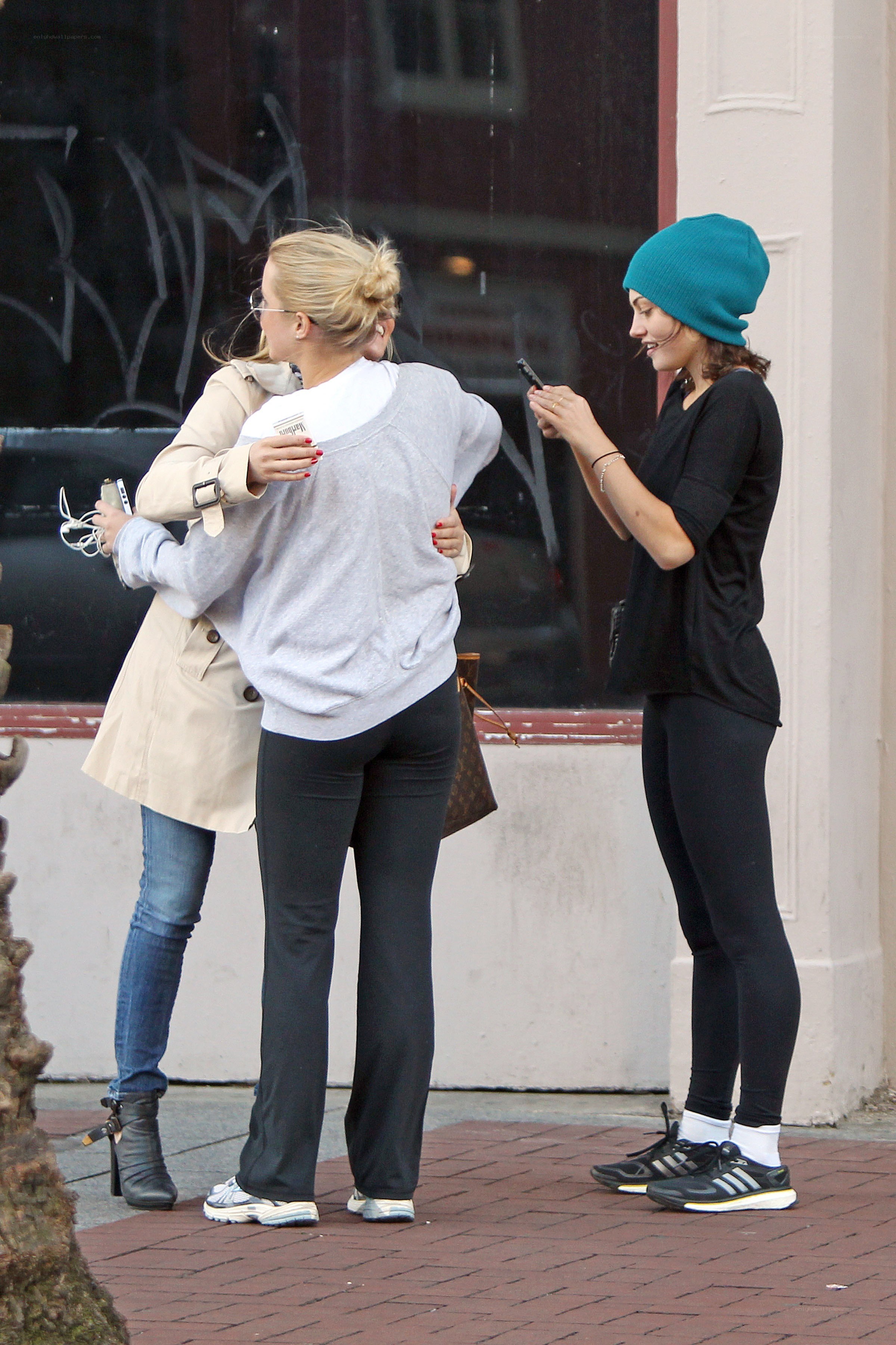 Women hugging on sidewalk