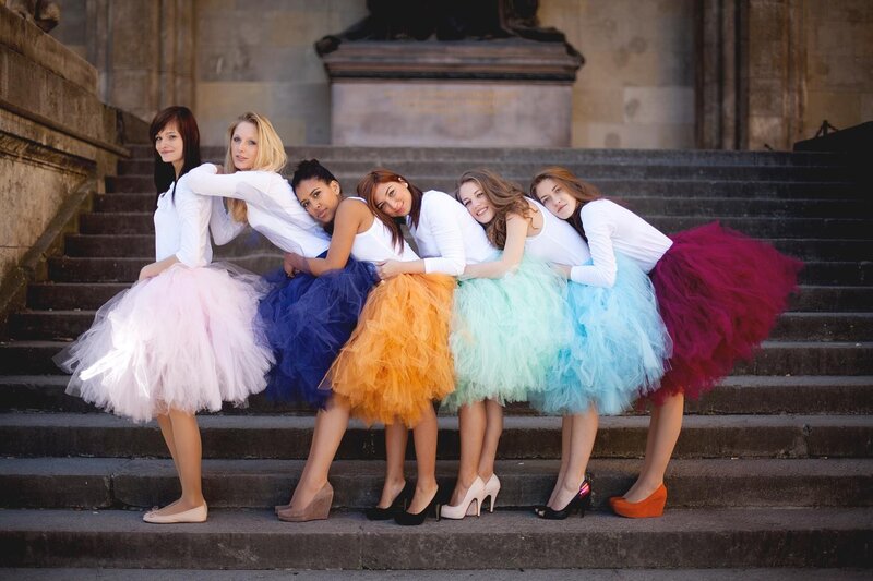 women in colorful tutus on steps