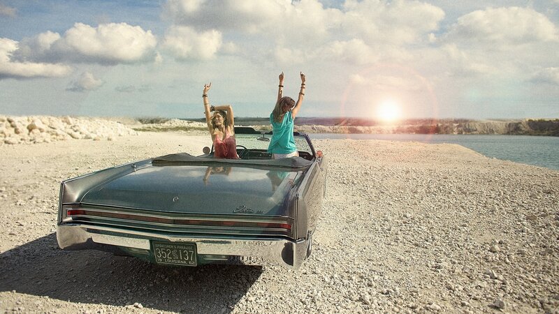 Women in convertible at sunset
