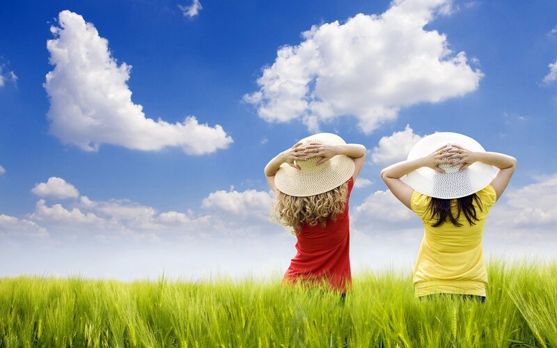 Women in field under blue sky