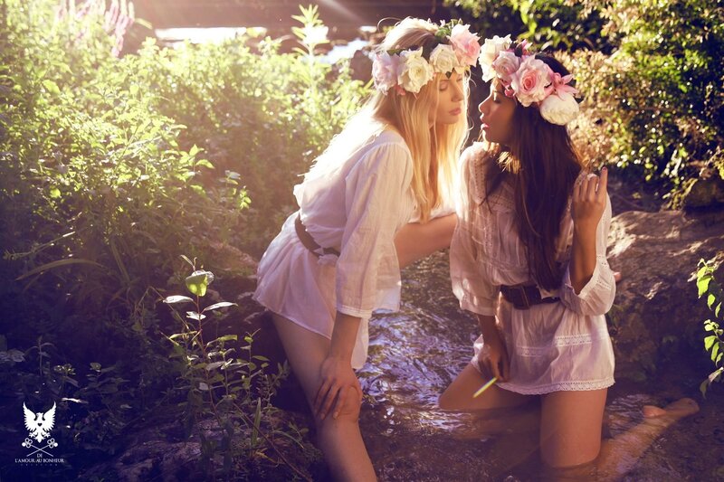 Women in floral crowns by stream