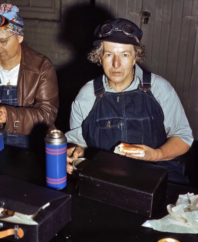 Women in overalls eating lunch