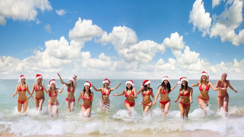 Women in Santa hats at beach
