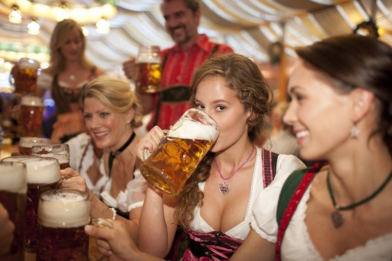 Women in traditional attire drinking beer