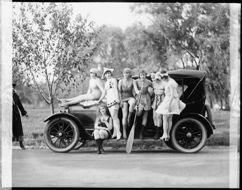 Women in vintage swimwear with car