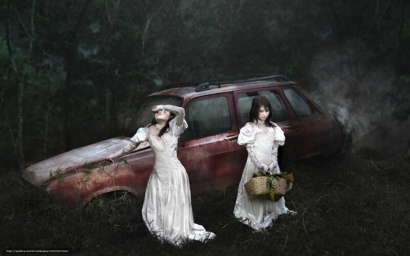 Women in white dresses by old car