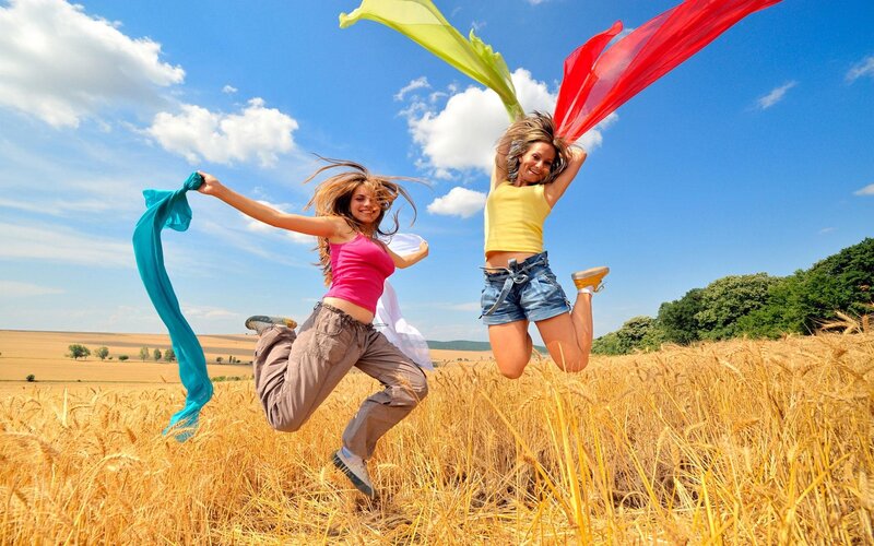 Women jumping in a wheat field