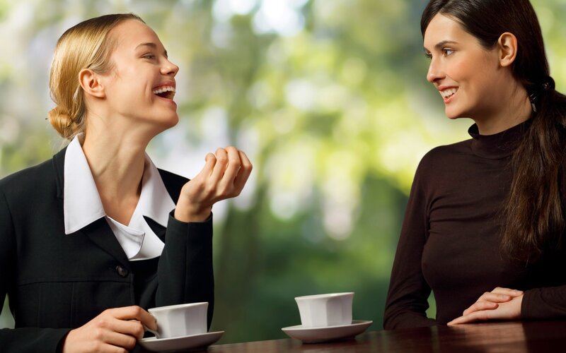 Women laughing over coffee