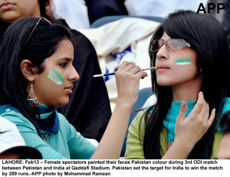Women painting faces for cricket match