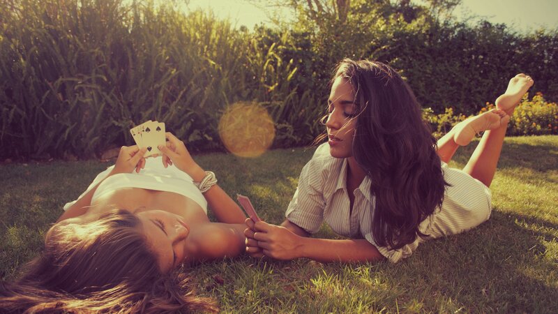 Women playing cards on grass