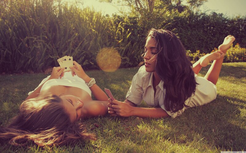 Women playing cards on grass