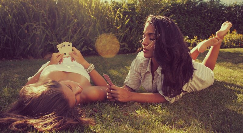 Women playing cards on grass
