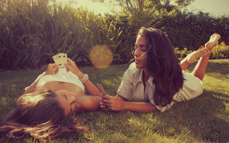 Women playing cards on grass