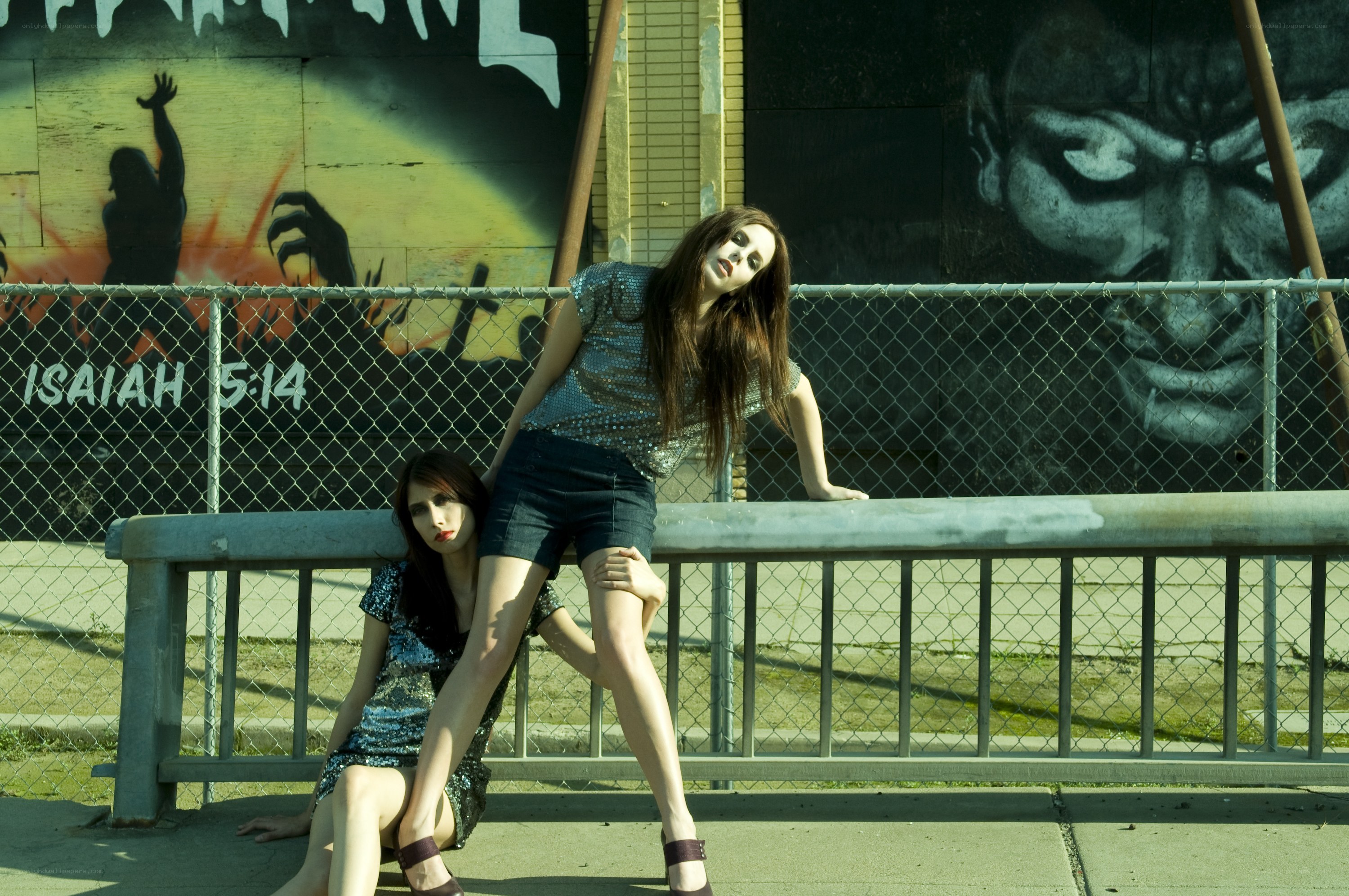 Women posing by graffiti wall
