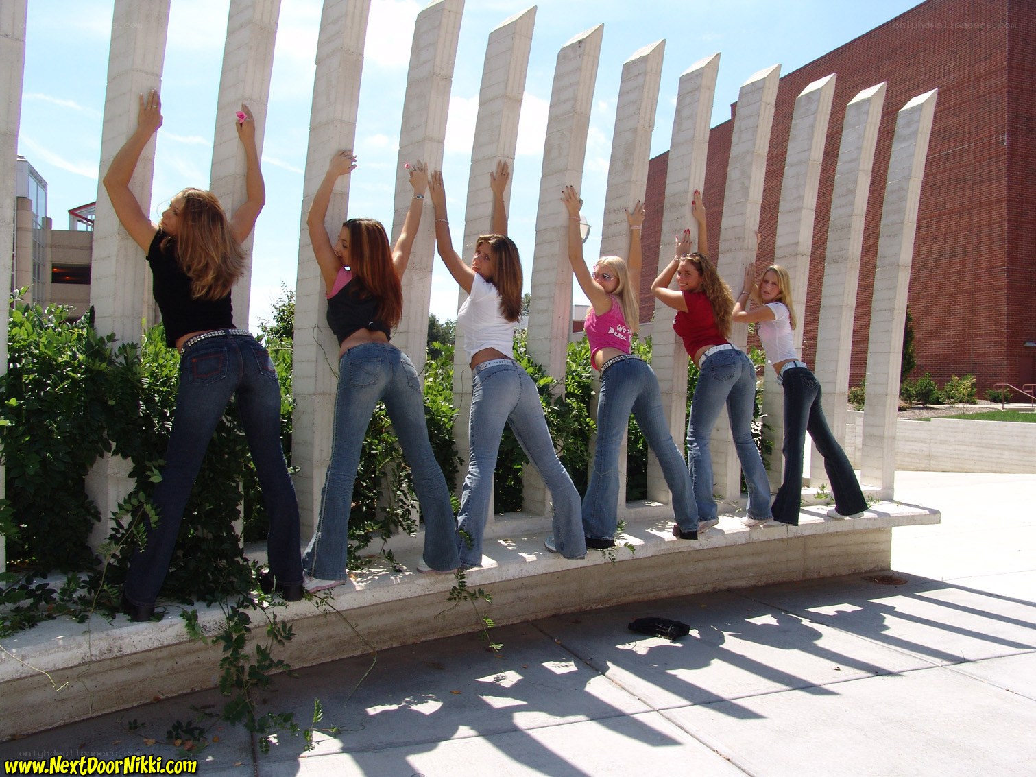 women posing by pillars