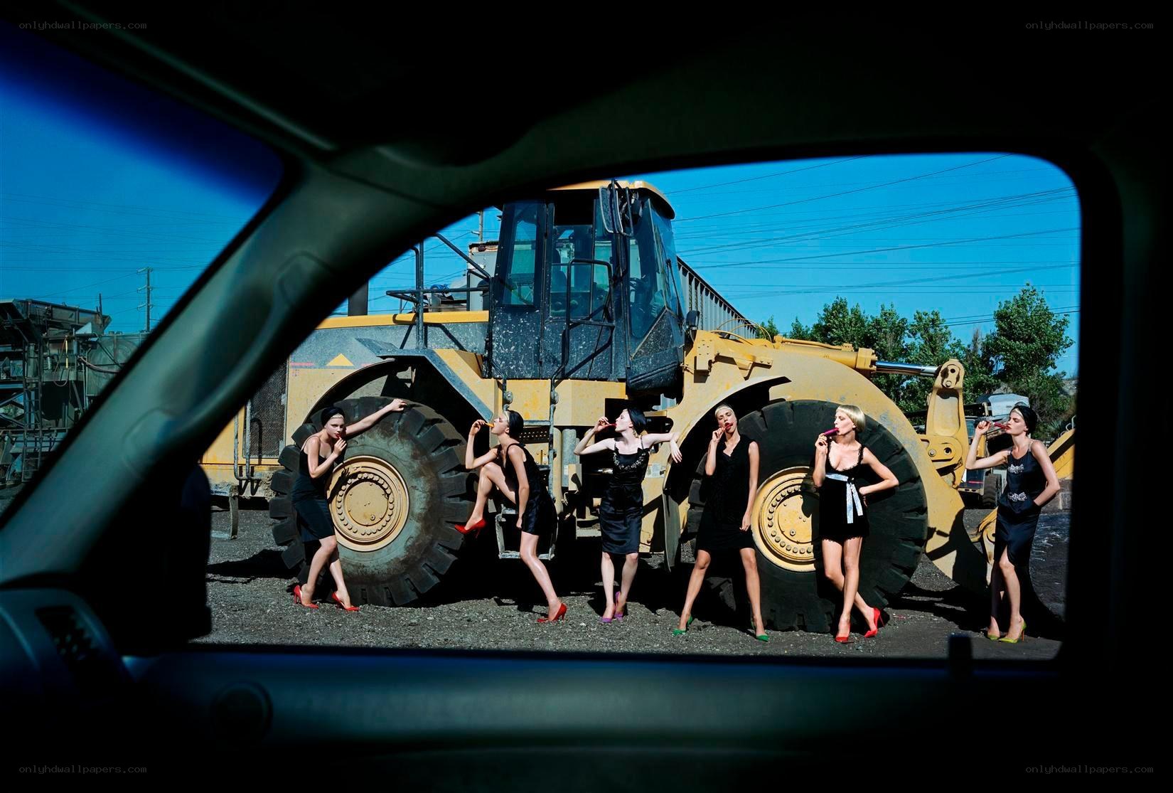 Women posing with construction vehicle