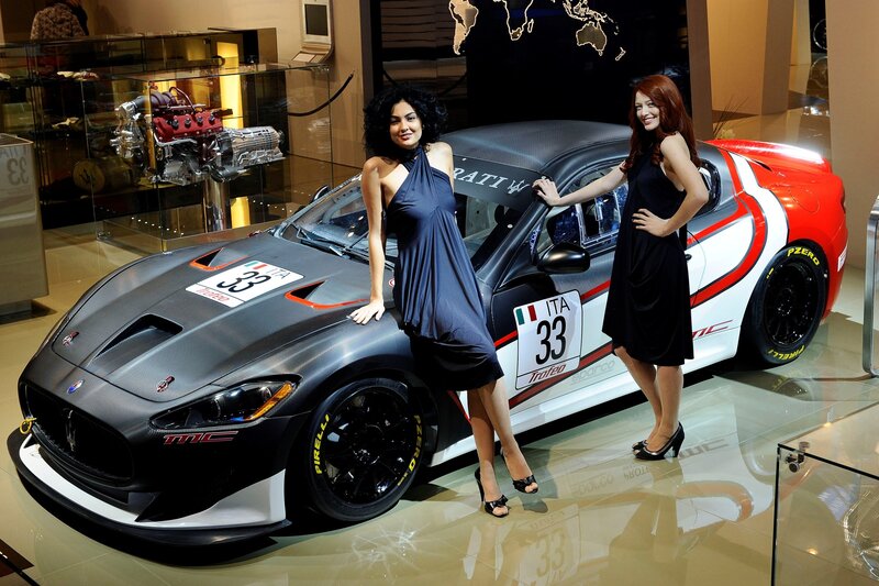 Women posing with race car