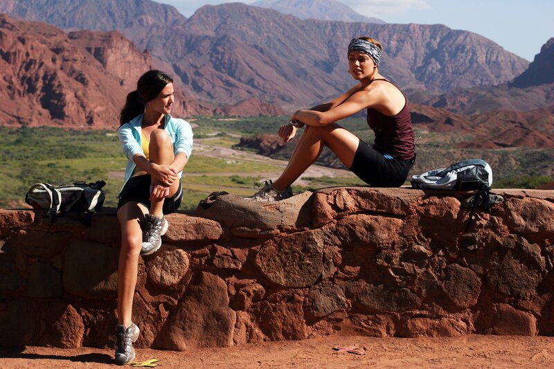 Women resting on a rock wall