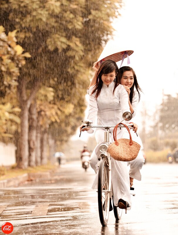Women riding bicycle in rain