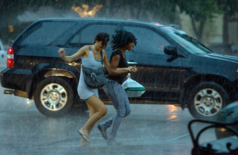 Women running from rain in street