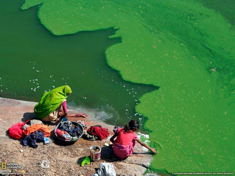 Women washing clothes in polluted water