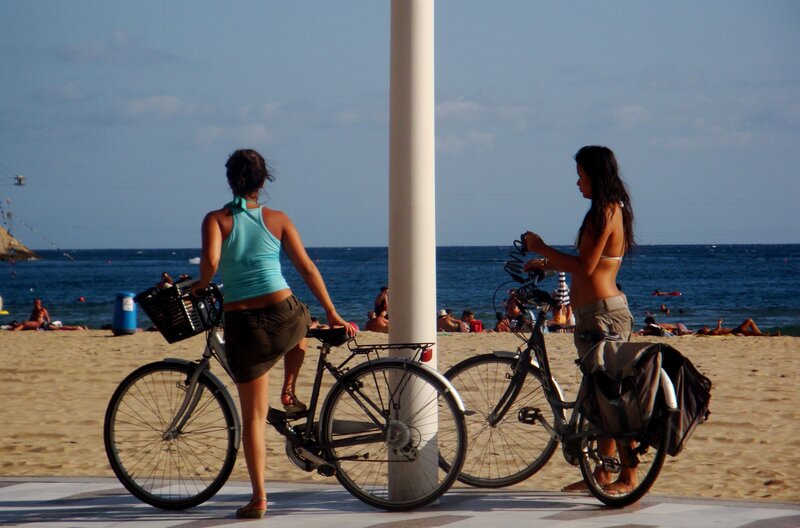 Women with bicycles on the beach